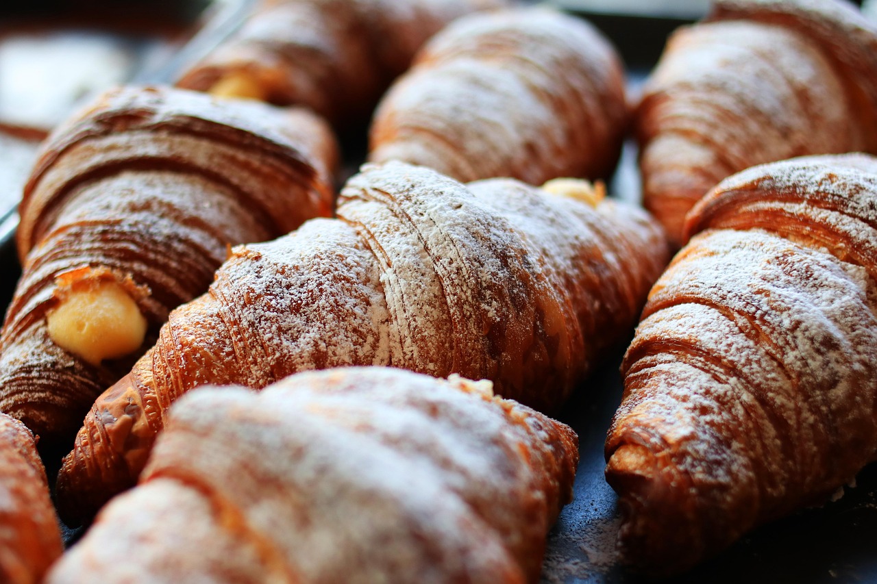 A selection of freshly baked croissants and pastries on a cooling rack.